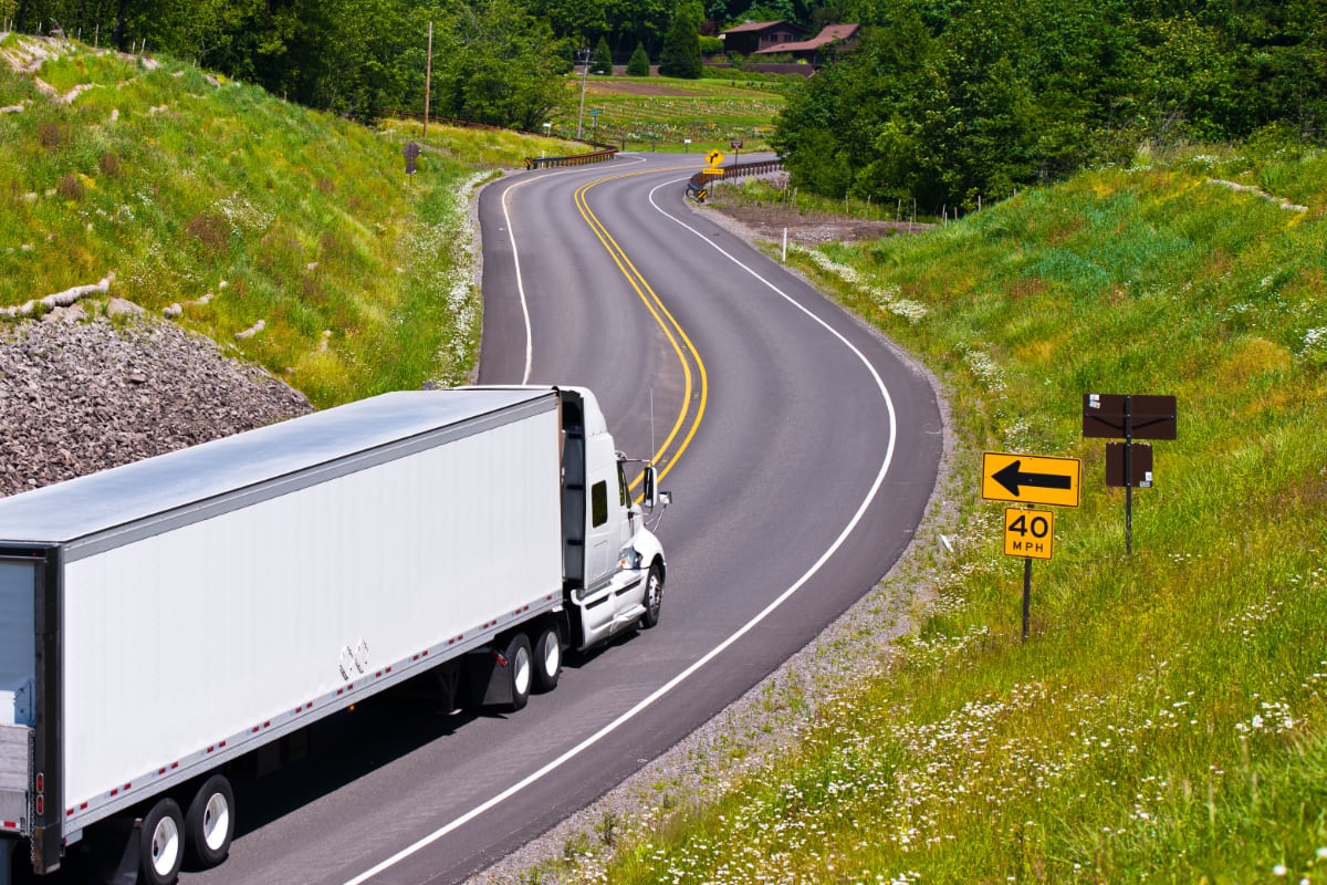 Commercial tractor trailer truck on curving road